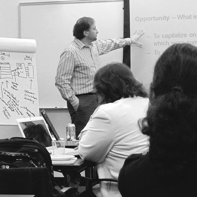 A black and white photo of a businessman giving a presentation